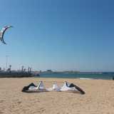 � un giovedi soleggiato di primavera quando arriviamo sulla spiaggia di Pane e Pomodoro, sulla quale sono adagiati due grandi aquiloni gonfiabili a forma di semicerchio, uno bianco e nero...
